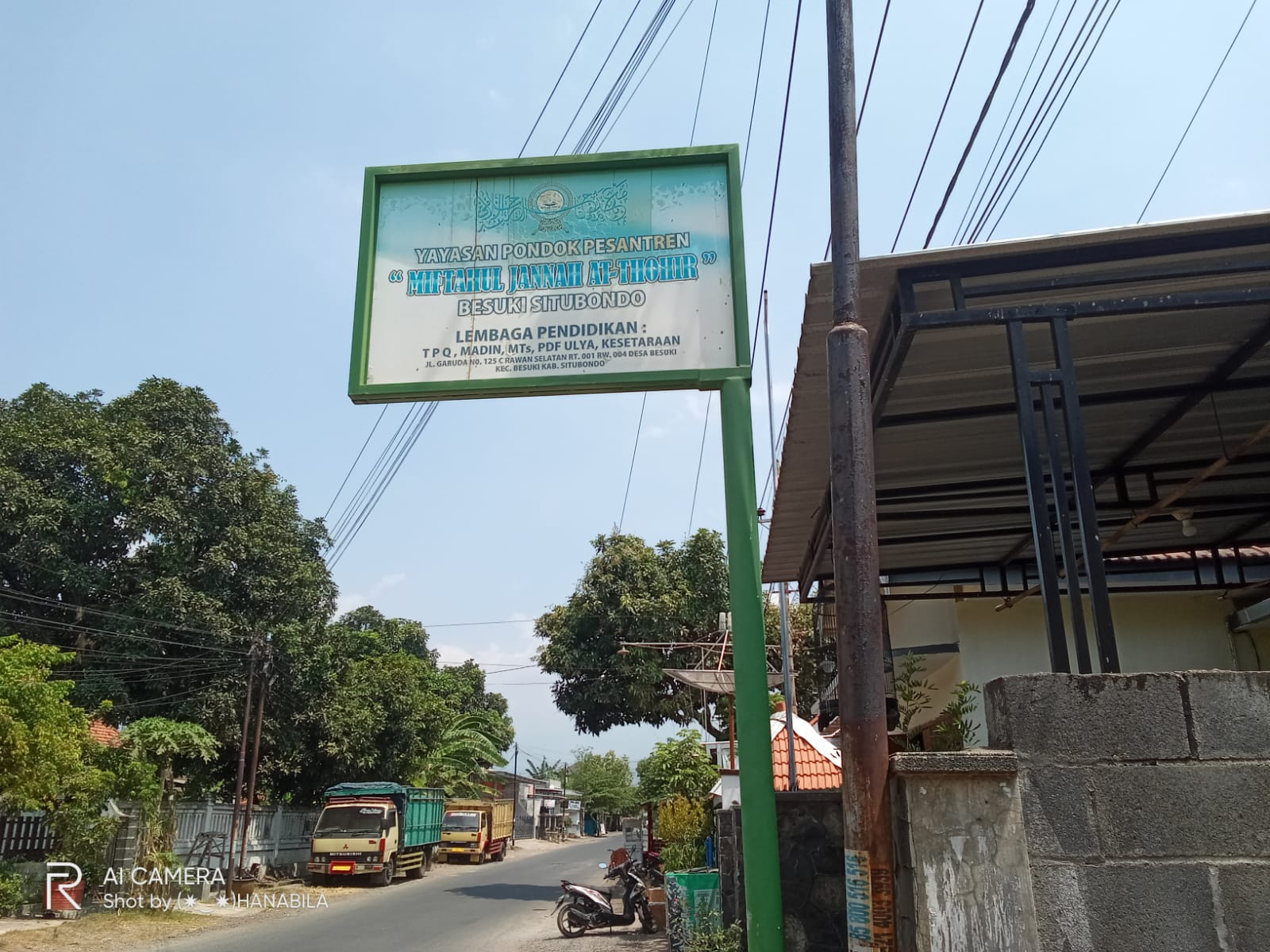 Bangunan sekolah modern dengan fasilitas lengkap, area hijau yang luas, dan siswa-siswa sedang beraktivitas